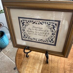 Scherenschnitte with quote about marriage with gold frame.